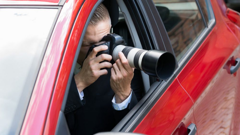 41318157 – close-up of a male driver photographing with slr camera from car